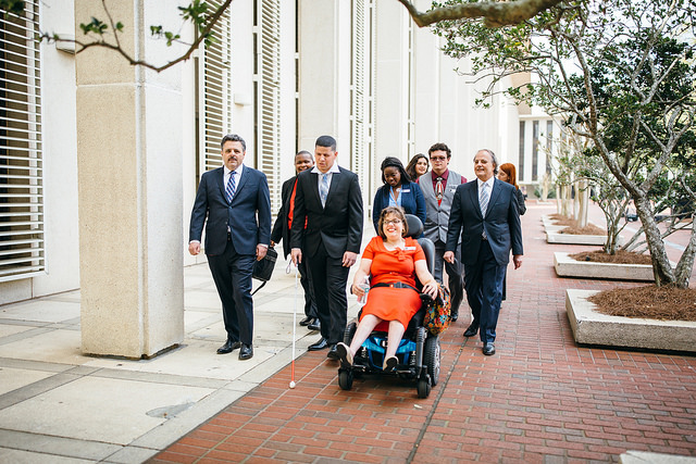 A group of youth walk with Eddie and Chuck Farah at the State Capitol