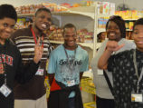 Five youth stand together for a picture with smiles.